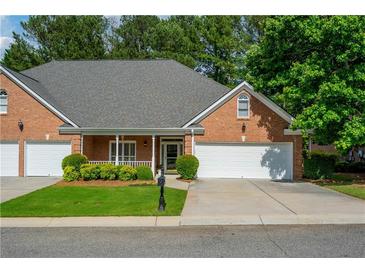 Charming single-story brick home features an attached two-car garage and manicured front lawn at 8675 Hope Vine, Roswell, GA 30076