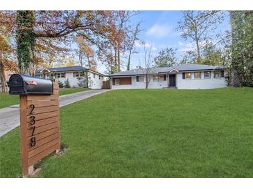 Charming ranch-style home with freshly painted exterior and expansive green lawn and an adjacent house sharing the driveway at 2378 Green Forrest Dr, Decatur, GA 30032