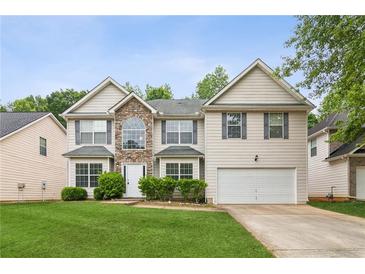 Two-story home featuring a stone facade, well-manicured lawn, and an attached two-car garage, on a sunny day at 2896 Chilhowee Dr, Atlanta, GA 30331