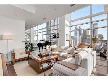 Bright living room featuring a modern design, floor-to-ceiling windows, and a grand piano overlooking the city at 45 Ivan Allen Jr Nw Blvd # 2705, Atlanta, GA 30308