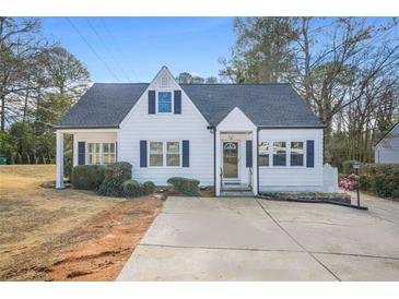 Charming cottage-style home featuring a well-maintained lawn and blue shutters at 1831 Dresden Dr, Brookhaven, GA 30319