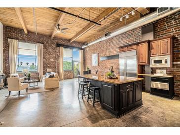 Bright living space featuring exposed brick, wood ceilings, and a kitchen island with seating at 204 Walker Sw St # 319, Atlanta, GA 30313