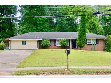 Charming brick ranch home with a well-maintained front lawn and mature trees at 3967 Norman Rd, Stone Mountain, GA 30083