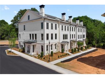 Stunning exterior view of townhome with balconies, brick facade, and professionally landscaped grounds at 415 Mayfair Ct, Alpharetta, GA 30009