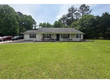 Charming single-story home with a large front lawn and inviting front porch at 4284 Village Green W Cir, Conyers, GA 30013