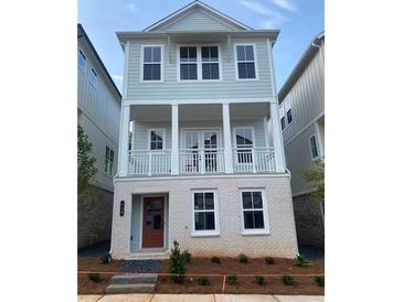Charming, two-story home featuring a welcoming front porch and light blue siding at 115 Pinecone Pkwy, Alpharetta, GA 30022