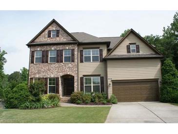 Charming two-story home featuring a brick and siding facade, well-manicured lawn, and a two-car garage at 4020 Alligator Pt, Cumming, GA 30028