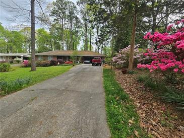 Charming single-story home featuring a long driveway and colorful landscaping at 2564 Wren Nw Ave, Duluth, GA 30096