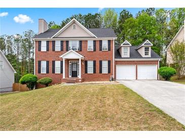 Charming two-story brick home with a manicured lawn and a two-car attached garage at 642 Towering Pine Trl, Lawrenceville, GA 30045