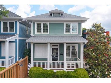 Charming two-story home featuring a welcoming front porch and light-green siding and trimmed with white at 630 John Wesley Dobbs Ne Ave, Atlanta, GA 30312