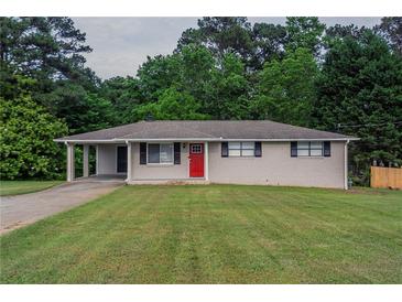 Charming single-story home with a well-maintained lawn, a bright red front door and convenient carport at 2290 Pope Rd, Douglasville, GA 30135
