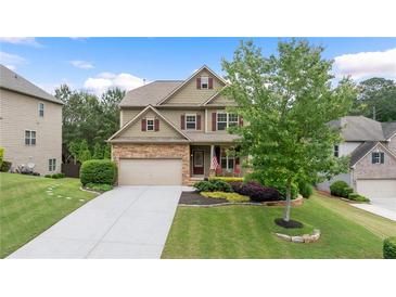Charming two-story home with a manicured lawn, a two-car garage, and stone accents at 1955 Piedmont Cove Ln, Cumming, GA 30040