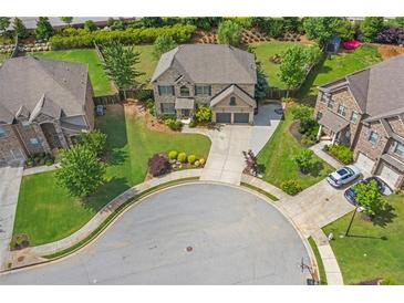 Aerial view of a beautiful brick home with well-manicured lawn and two-car garage on a cul-de-sac lot at 3179 Falls Crest Ct, Buford, GA 30519