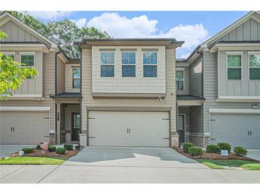 Charming townhome with a two-car garage, neutral siding, and well-maintained landscaping at 450 Rockfern Ct, Lilburn, GA 30047