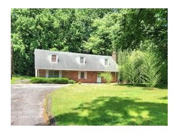 Charming brick home featuring a well-maintained lawn and mature trees, offering a serene and private setting at 1431 Woodland Sw Ter, Atlanta, GA 30311