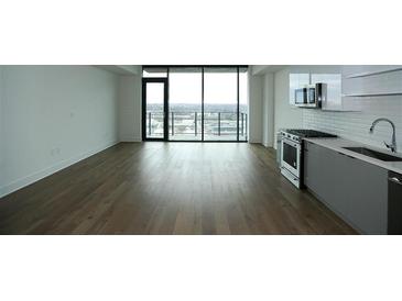 Bright living room features a large window with city views and a modern kitchen at 788 W Marietta Nw St # 811, Atlanta, GA 30318