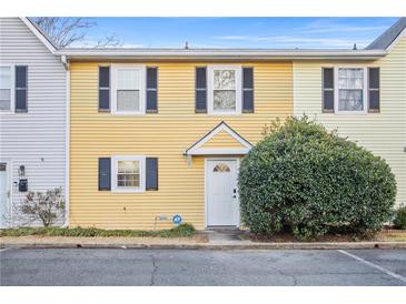Charming yellow townhouse featuring black shutters and a well-manicured front yard at 2858 Spring Villa Se Ln, Smyrna, GA 30080
