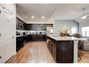 Spacious kitchen featuring dark wood cabinets, granite countertops, and stainless steel appliances at 64 Citadel Dr, Hampton, GA 30228