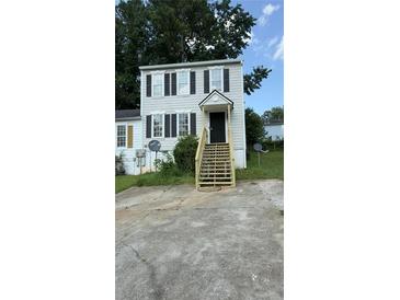 Two-story home featuring neutral siding, complementary black shutters, and wooden stairway up to covered front entry at 3464 Kingswood Trl, Decatur, GA 30034