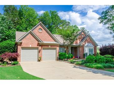 Charming brick home featuring a well-manicured lawn, two-car garage, and beautiful landscaping at 1460 Badingham Dr, Cumming, GA 30041