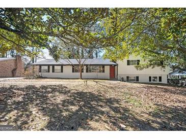 Charming ranch-style home with a combination of white brick and siding and mature trees in the front yard at 1887 King Charles Sw Rd, Atlanta, GA 30331