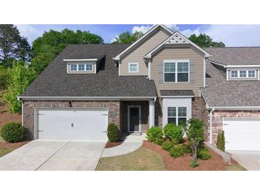 Charming townhome features a two-car garage, brick facade, and manicured landscaping at 2706 Park Land Ln, Snellville, GA 30078