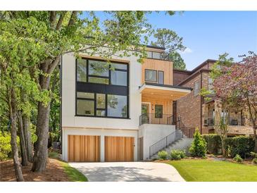 Modern home with a two-car garage and a combination of light-colored siding and wood panels at 1287 Star Ne Dr, Brookhaven, GA 30319