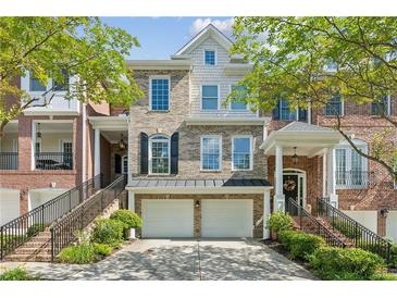 Beautiful townhouse with a brick facade, two-car garage, and charming curb appeal, perfect for modern living at 5882 Riverstone Cir # 15, Atlanta, GA 30339