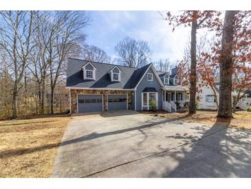 Charming blue two-story home with a stone garage and a well-maintained front yard at 1931 Amber Dawn Way, Lawrenceville, GA 30043