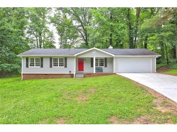 Charming single-story home featuring a red front door, attached garage, and a well-manicured lawn at 3963 Holland Ct, Douglasville, GA 30135