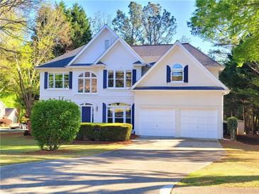Charming two-story home featuring blue shutters, a manicured lawn, and a two-car garage at 505 Tilbury Dr, Suwanee, GA 30024