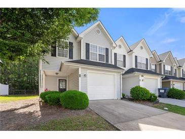 Charming townhome featuring a one-car garage, manicured landscaping, and neutral siding for a welcoming curb appeal at 6901 Gallant Se Cir # 13, Mableton, GA 30126