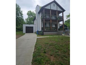 Charming two-story home with a large front yard, two porches, and an attached garage at 1228 Ladd Sw St, Atlanta, GA 30310