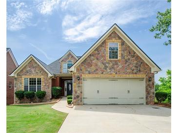 Charming stone and siding home featuring a two-car garage and manicured lawn at 9157 Golfview Cir, Covington, GA 30014