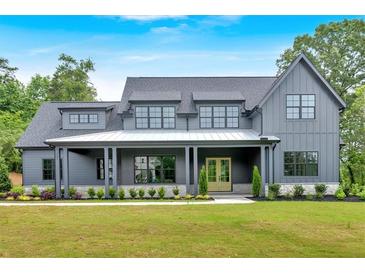Stunning gray modern farmhouse with a covered porch, double doors, and professionally landscaped front yard at 157 Palisade Ne Dr, Rydal, GA 30171