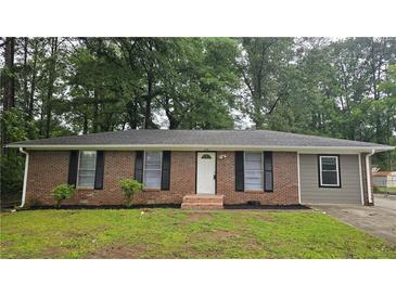 Charming single-story brick home featuring classic shutters and a well-maintained front yard at 679 Winchester Ln, Norcross, GA 30071
