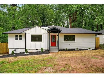 Charming home with a red door, landscaped yard, and fresh white paint at 1599 Sandtown Rd, Atlanta, GA 30311
