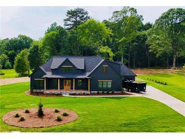 Beautiful two-story home boasts a black exterior, spacious yard and wooded backdrop at 1111 Lake Varner Dr, Covington, GA 30014