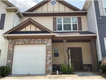 Charming two-story townhome with a stone front and a one car garage and a covered entry at 6941 Rogers Pt, Lithonia, GA 30058