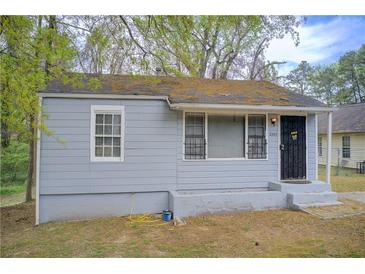 Modest single-story home with gray siding, black security door, and visible signs of wear and tear at 2293 Ewing Sw St, Atlanta, GA 30331
