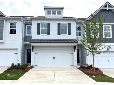 Charming townhome featuring a white brick facade and a two-car garage at 1958 Asher Ln # 50, Conyers, GA 30013