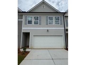 Charming two-story townhome with a gray color scheme, attached garage, and a well-maintained lawn at 1023 Merritt Dr # 100, Villa Rica, GA 30180