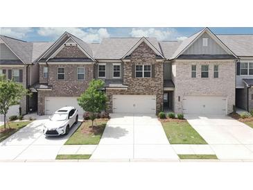 Charming brick townhomes with attached garages and well-manicured lawns present a welcoming curb appeal at 2924 Weyhill Trl, Buford, GA 30519