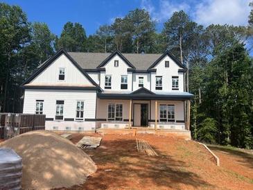 New two-story home featuring white siding, black trim, and symmetrical windows at 3425 Dr Bramblett Rd, Cumming, GA 30028