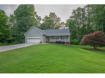 Charming single-story home boasts a well-manicured lawn, attached garage, and inviting front porch at 399 Towler Drs, Loganville, GA 30052