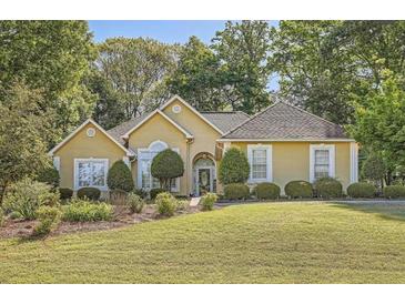 Charming single-story home with a manicured lawn, mature trees, and a welcoming front entrance, perfect for suburban living at 184 Glenn Eagles Way, Hiram, GA 30141