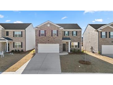 Charming two-story brick home with a two-car garage and well-maintained front yard at 1483 Autumn Wind Dr, Dacula, GA 30019