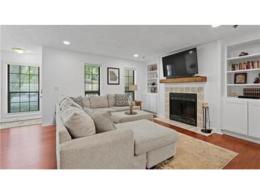 Inviting living room with a large sectional sofa, fireplace, TV, and built-in bookshelves at 2808 Vinings Central Se Dr # 158, Atlanta, GA 30339