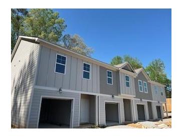 Gray two-story townhome boasts a one-car garage and neutral trim at 4263 Notting Hill Sw Dr, Atlanta, GA 30331