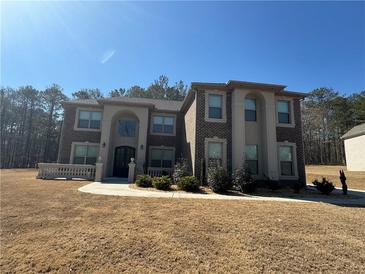 Stately brick home featuring manicured landscaping and elegant architectural details on a sunny day at 2709 Ratby Ne Ln, Conyers, GA 30013